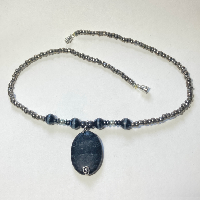 Polished piece of blue tigers eye with simple beads