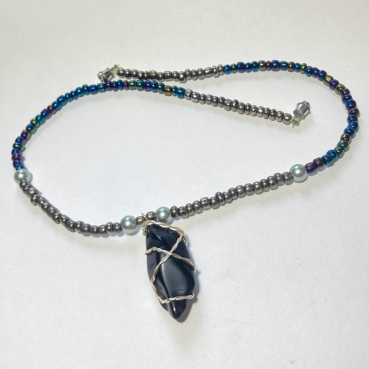 Interesting chunk of black obsidian with subtly colored beads