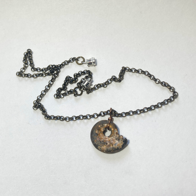 Small Jurassic-period ammonite on a brass chain