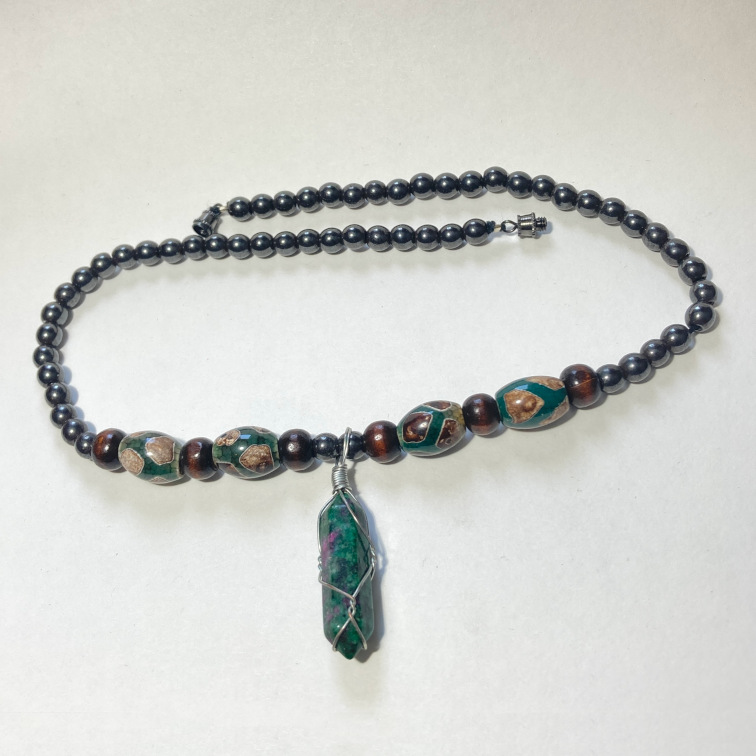 Hematite beads with a ruby-in-zoisite pendant and mixed material accents